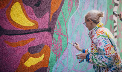 Young Female Artist Creating Mural: NYC Commercial Real Estate Art