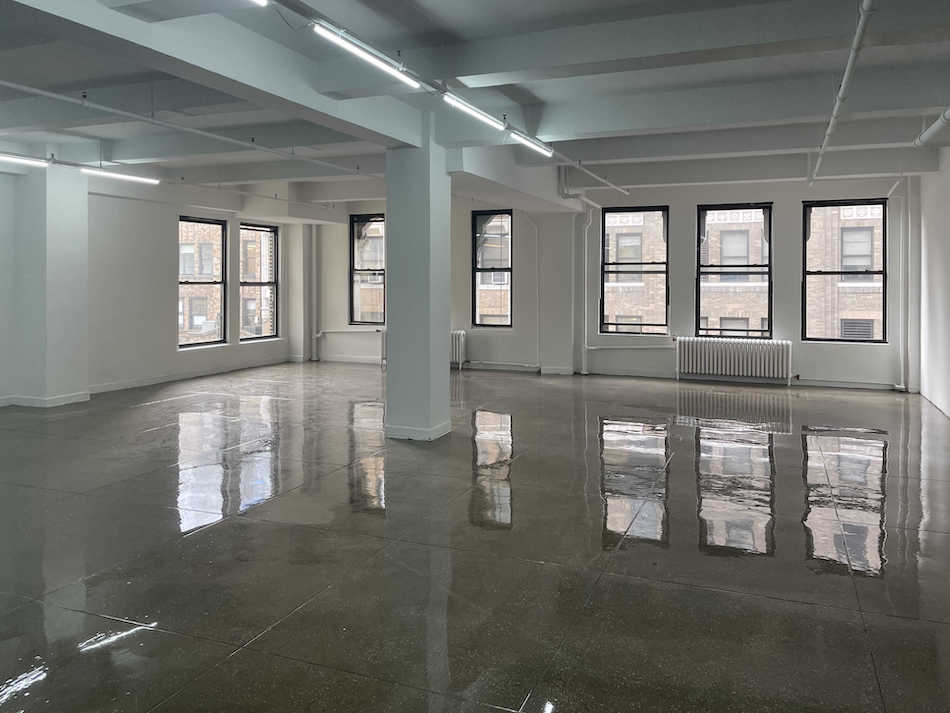 Bright corner office space for lease at 265 West 37th Street, featuring polished concrete floors.