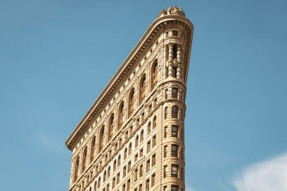 July afternoon view of Flatiron Building in New York City, potential commercial real estate sale.