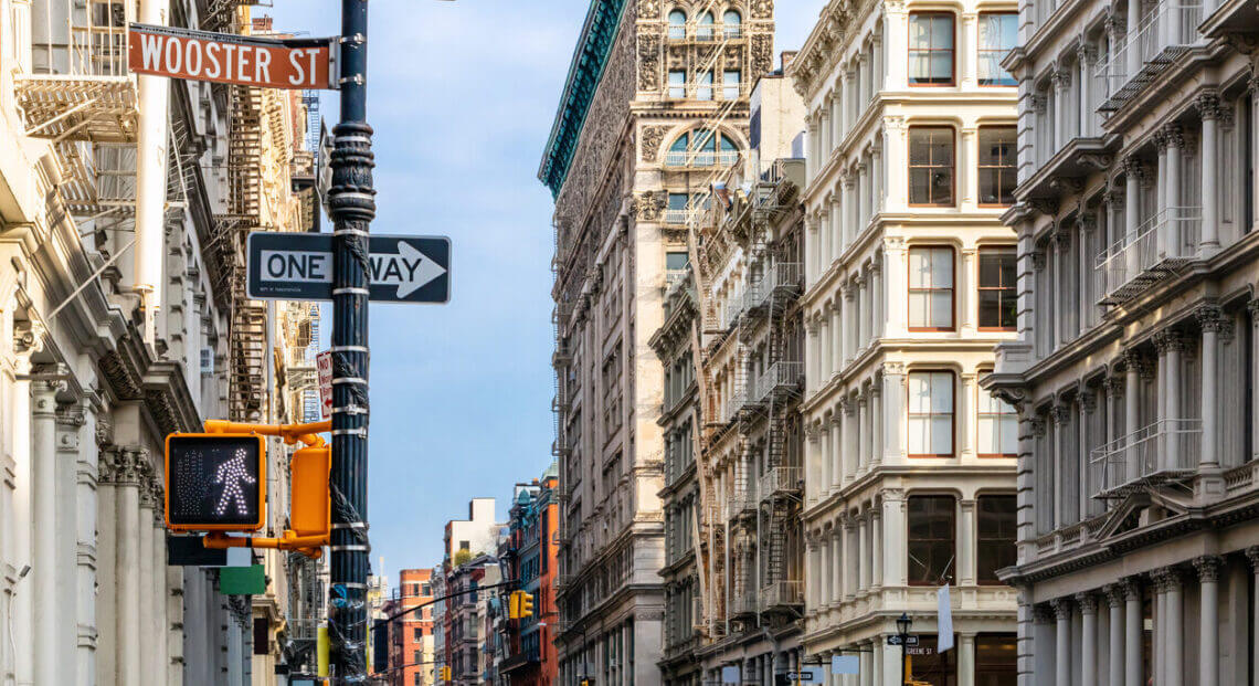 SoHo's Broome & Wooster Streets in NYC: historic cast iron and brick buildings now offices.